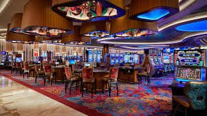 Filipino player aiming cannon at fish on slot monitor arcade shooting table